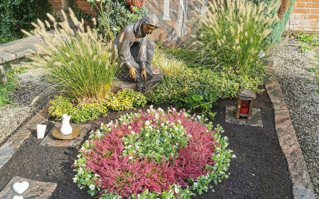 Grab mit Blumen und einer Statur