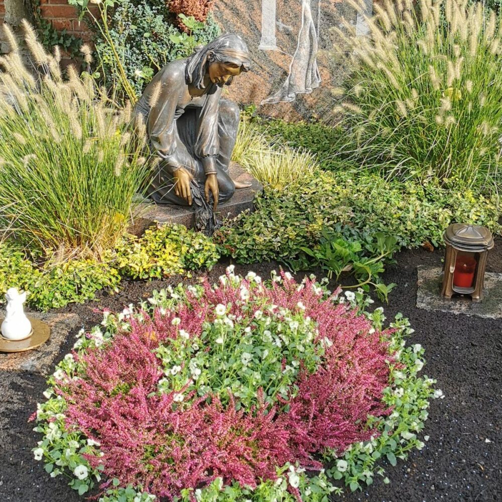 Grab mit Blumen und einer Statur