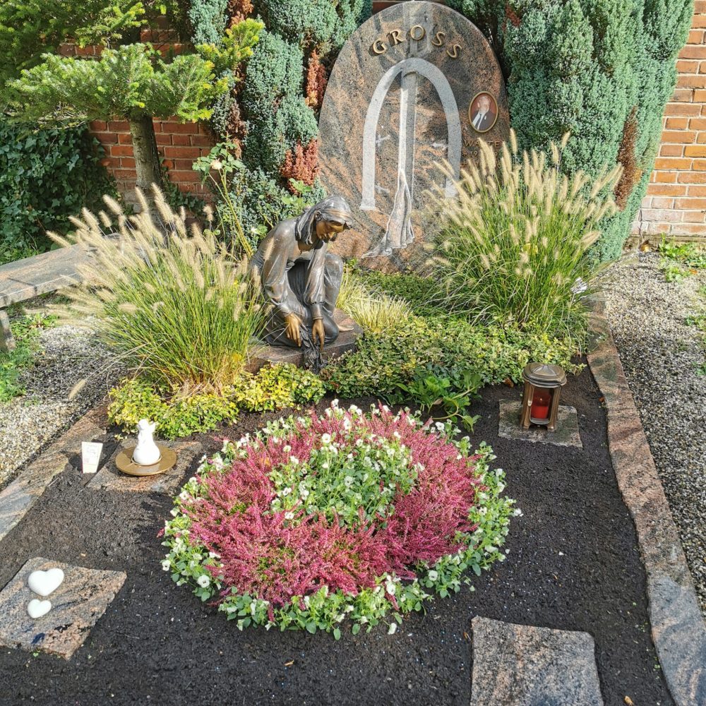 Grab mit Blumen und einer Statur